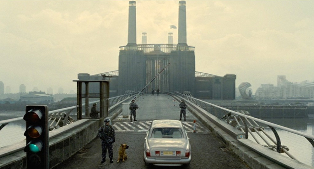 Fig. 1: Establishing shot: indstillingen der introducerer ”The Court of the Crimson King”-scenen i Children of Men er en tydelig henvisning til Pink Floyds album Animals (1977). Både film og album har en lyserød gris svævende mellem skorstenene på den ikonografiske Battersea Power Station i London.