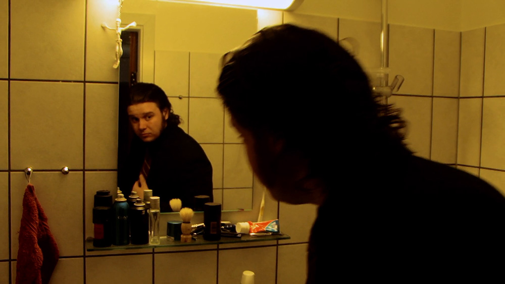 Fig. 5: Henrik betragter sig selv i spejlet, måske som et lille vink om, at han i filmen bliver tvunget til at se indad og tage sit liv op til revision.
