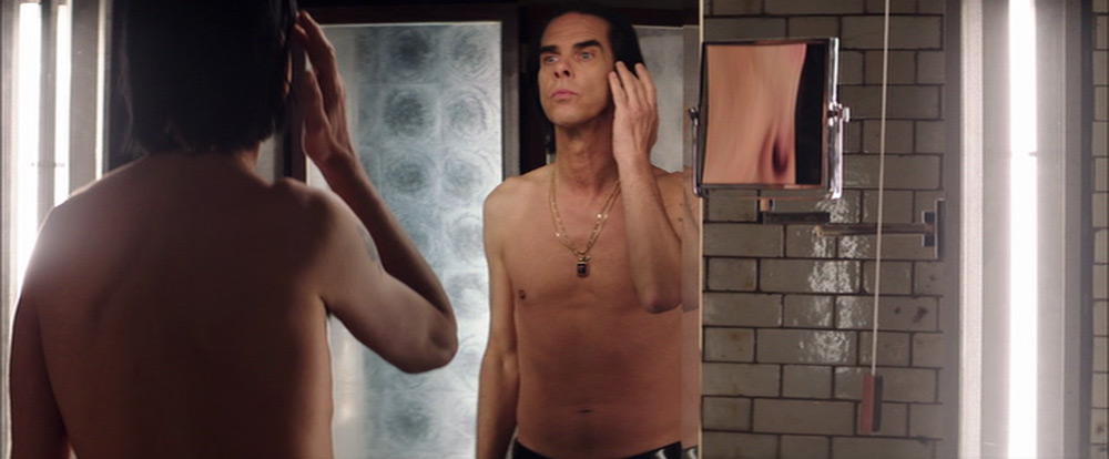 Fig. 3. I en steril konstruktion af lys og spejle studerer Nick Cave sig selv pertentligt, som om figuren i spejlet er en anden.