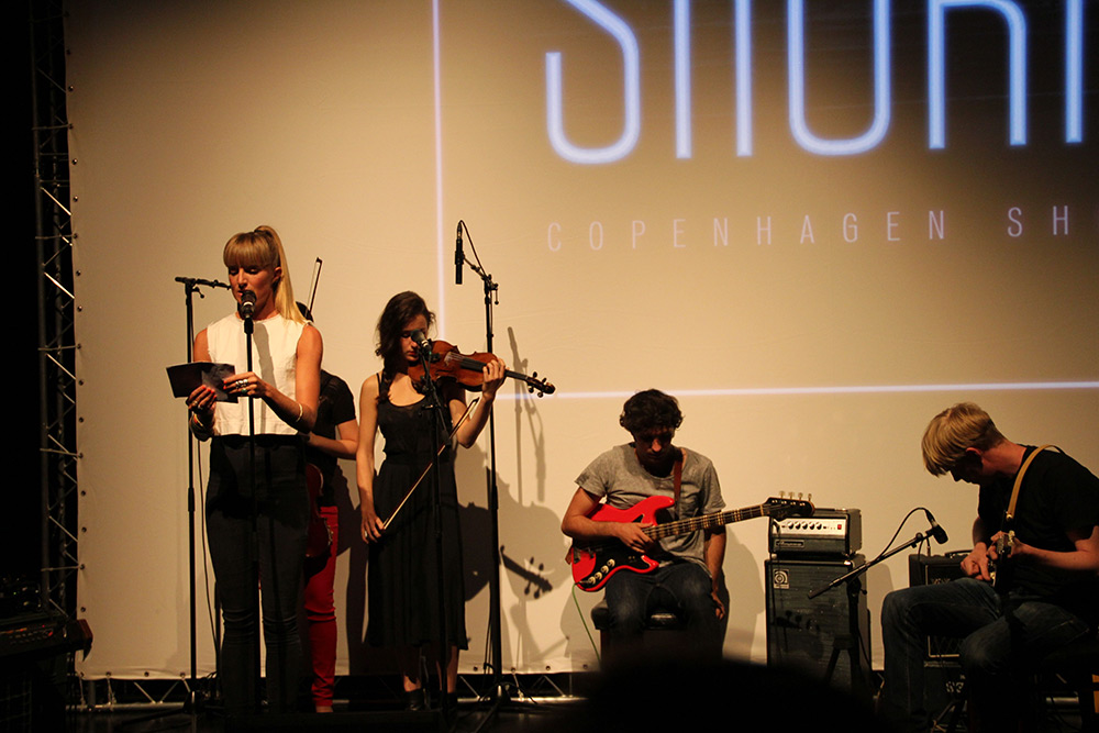 Fig 2: Udover filmpremiererne satte Shorts Cuts-arrangementet fokus på filmkomponisternes arbejde med tre små koncerter som optakt til filmene. Her præsenterer Nadja Nørgaard Kristensen komponisterne Manon Parent og Anders Christophersen, som gav prøver på deres filmmusik til Riders. Foto: Anne Uhrenholt Kjeldsen.