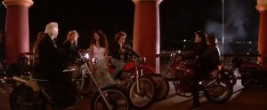 Fig. 13:The Lost Boys (1987) henviser til klassiske juvenile delinquent-film, fx The Wild One (1953) med Marlon Brando, og nogle af 1960’ernes og 1970’ernes film om utilpassende men tiltrækkende unge fyre fra ”the wrong side of the tracks”, heriblandt West Side Story (1964), The Wild Angels (1966) og Grease (1978). Bemærk hvordan den unge, flotte pige kigger intenst og interesseret på den vilde David. Det kan nok være at han er farlig, men han er også dragende og tillokkende.